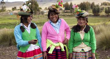 Drei junge Frauen in peruanischer Tracht bei der Gemeinschaftsarbeit